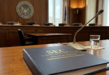 Tokenización: la SEC la sitúa como riesgo prioritario Mesa de madera con micrófono y carpeta oficial en una sala formal de comisiones (imagen generada por IA)